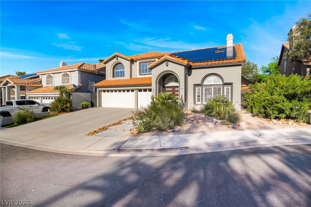 Spanish tile roofing and modern solar panels crown this beautifully designed multi-level residence.