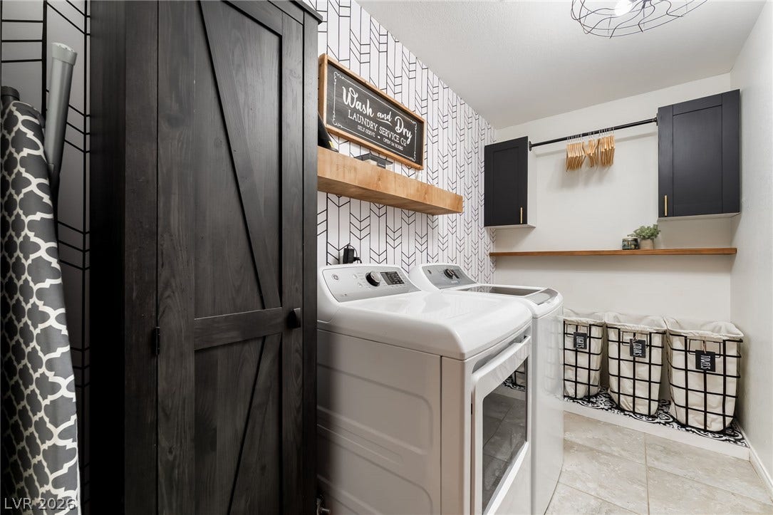A stylish, functional utility space featuring patterned accent walls alongside ample cabinet storage.