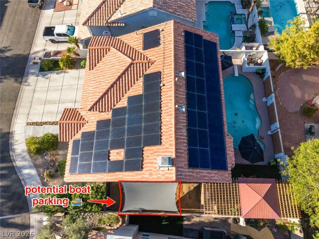 An aerial perspective showcases the extensive solar panel array on the Spanish tile roof.