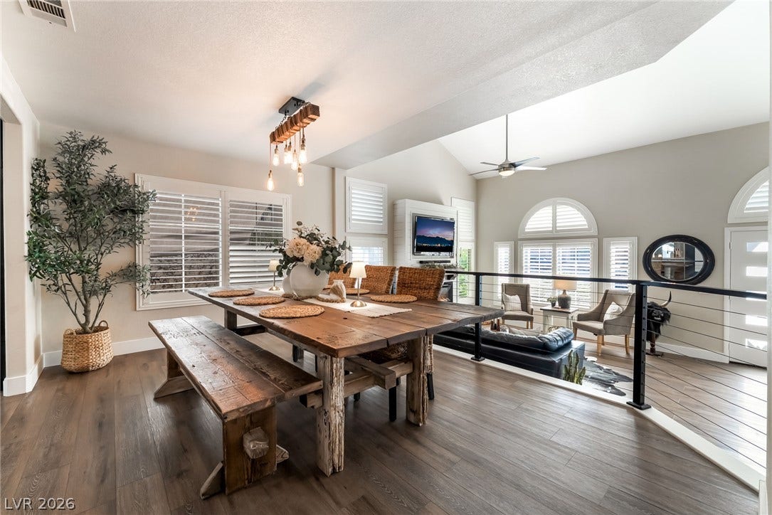 Rich wood flooring pairs beautifully with plantation shutters in this elevated dining space.