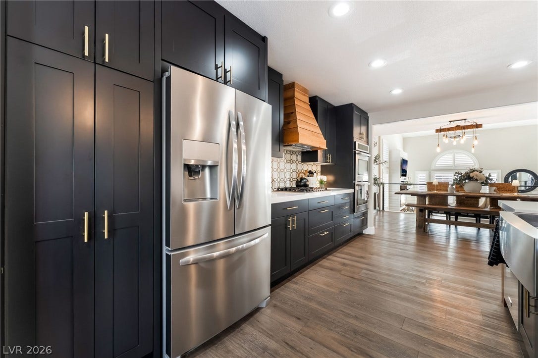 Gleaming hardwood floors and dark cabinetry define this open-plan cooking space.