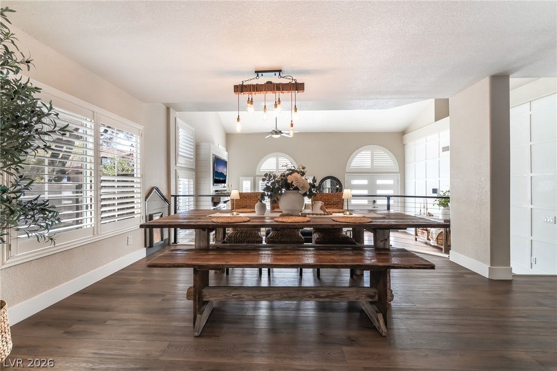 Rich wood-look flooring and custom shutters elevate this open dining environment.