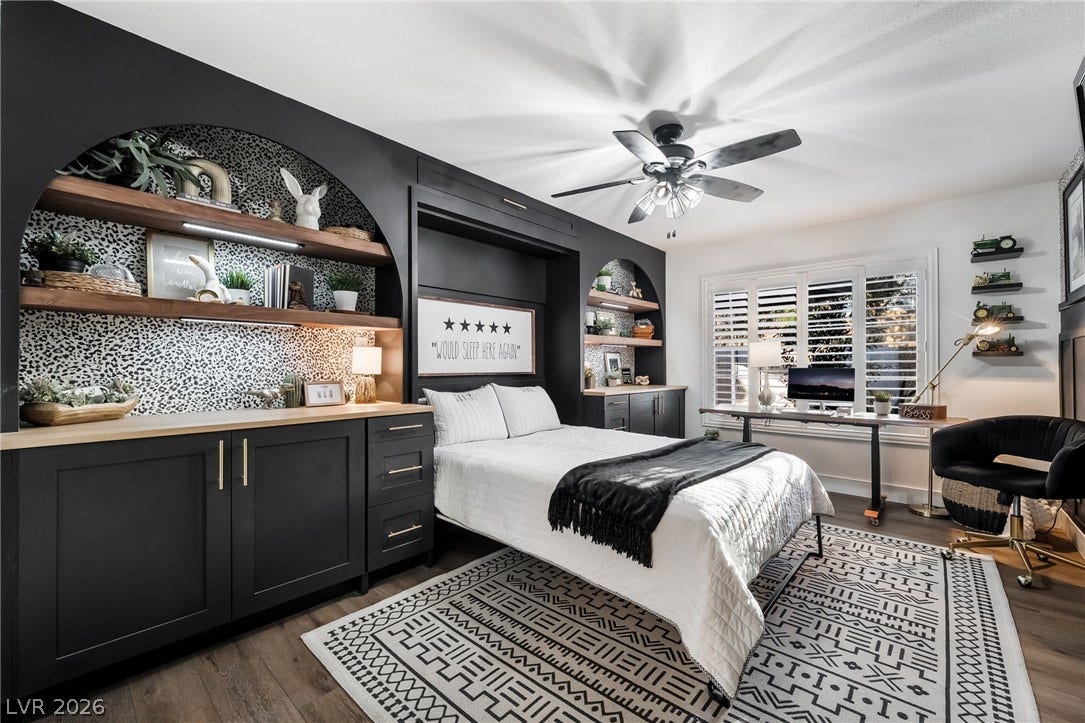 A stylish murphy bed system anchors this bedroom, flanked by arched built-in shelving.
