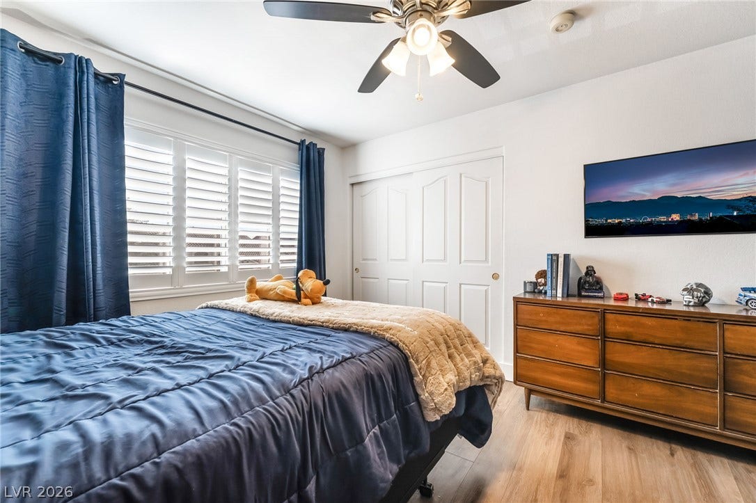 Hardwood floors and plantation shutters define this inviting bedroom space.