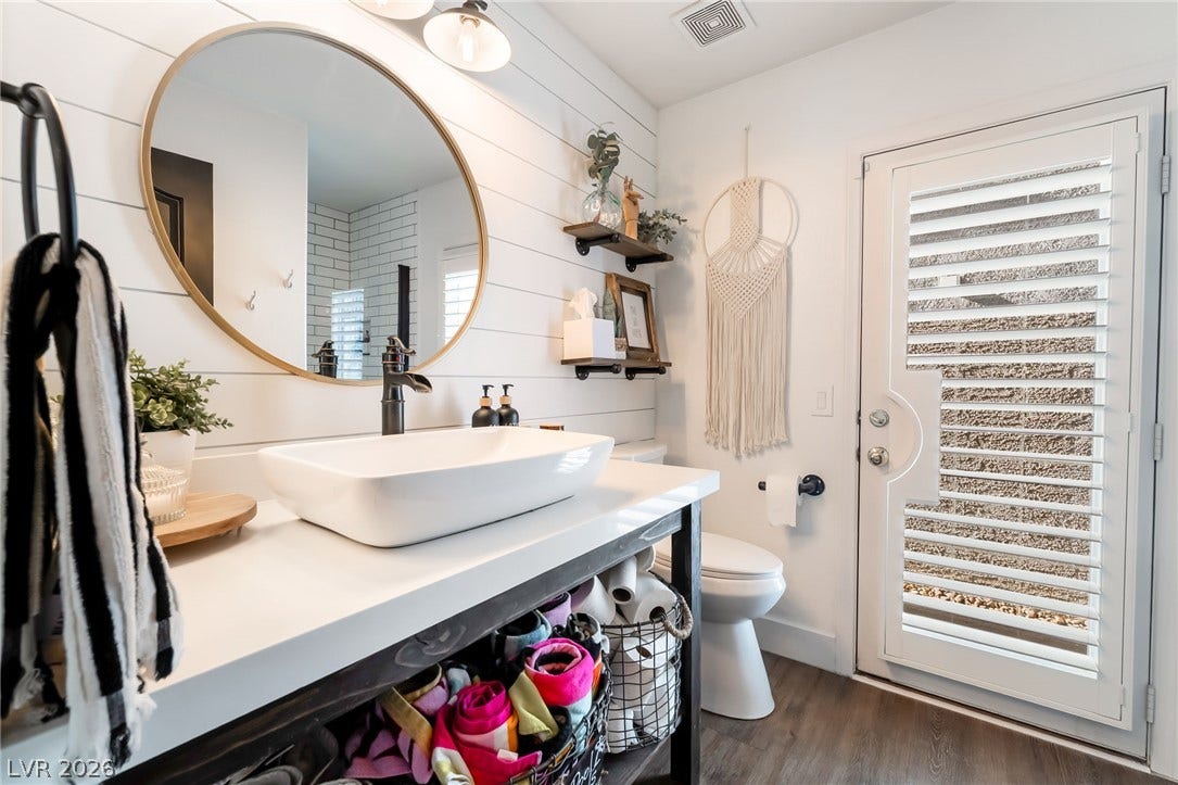 Shiplap wall detailing and a modern vessel sink elevate this stylish bathroom space.