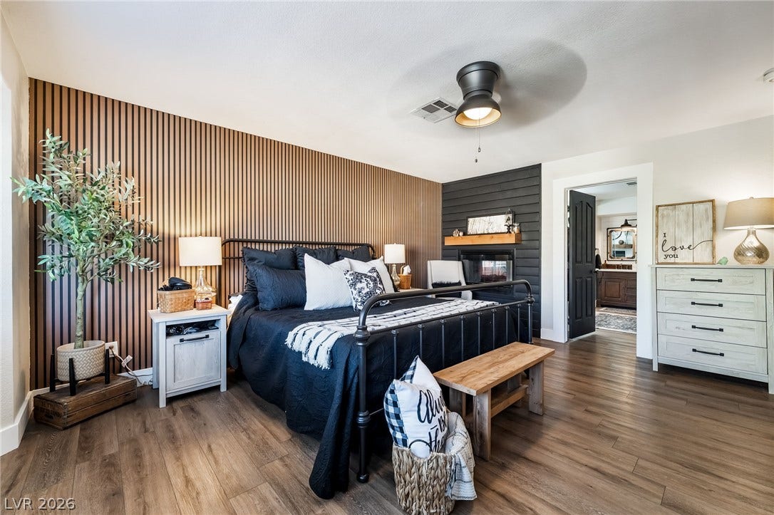 Rich wood plank flooring and detailed paneling accent this comfortable master suite.