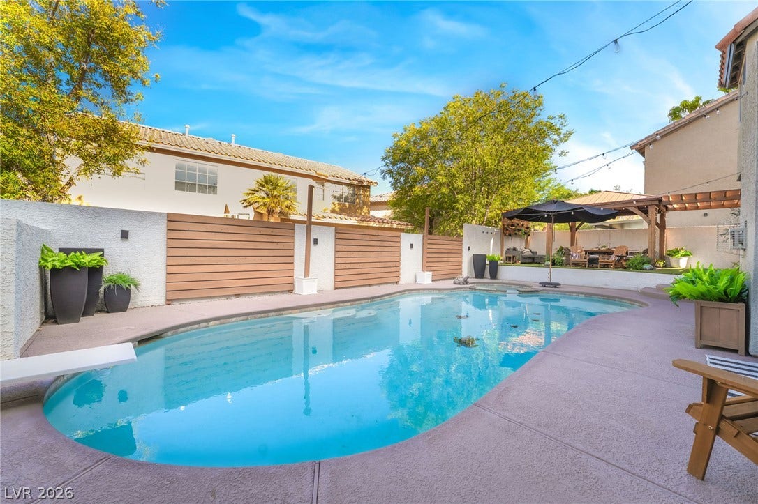 An inviting backyard swimming pool is bordered by concrete decking and private fencing.