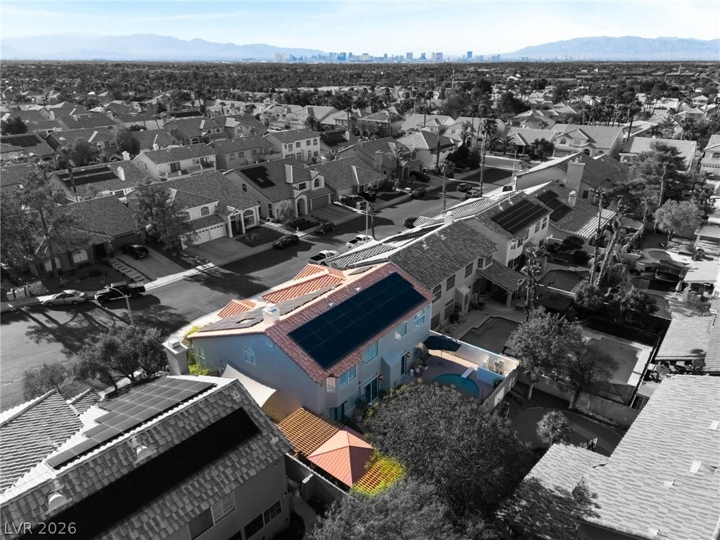 An aerial view showcases the neighborhood layout and distant skyline.