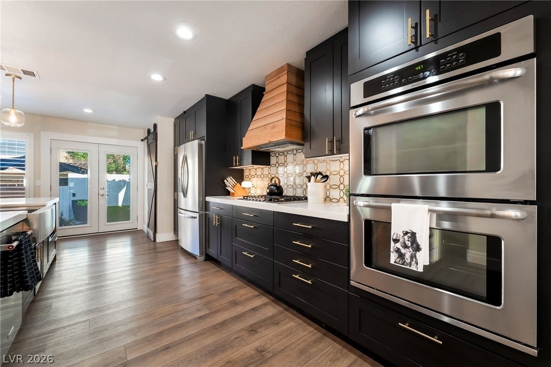 Gleaming hardwood floors and dark cabinetry anchor this beautifully updated gourmet kitchen.