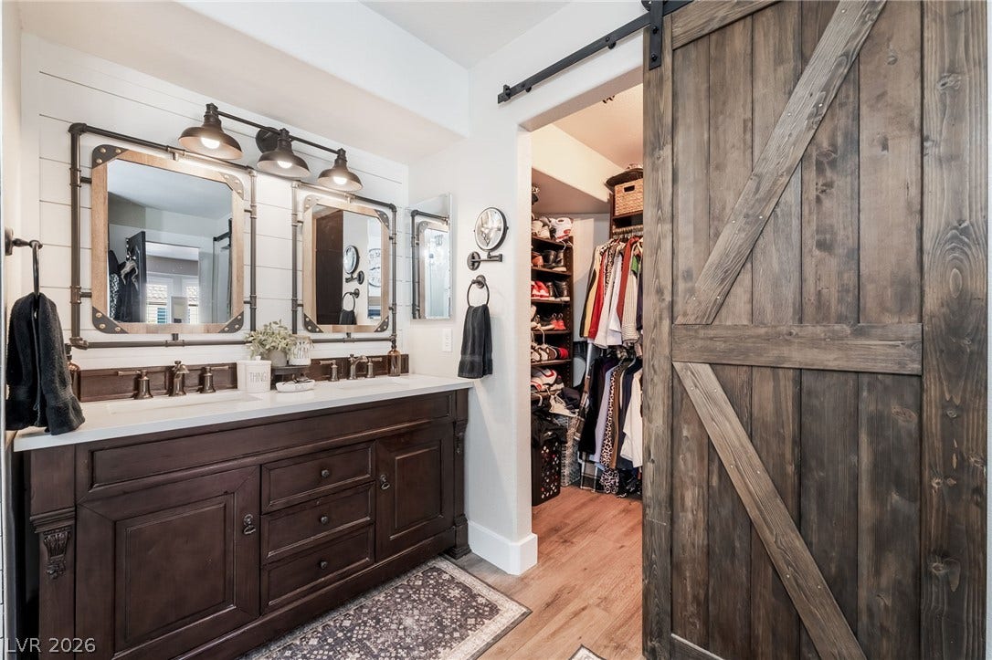 Double vanities and a rustic sliding barn door enhance this functional master bathroom.
