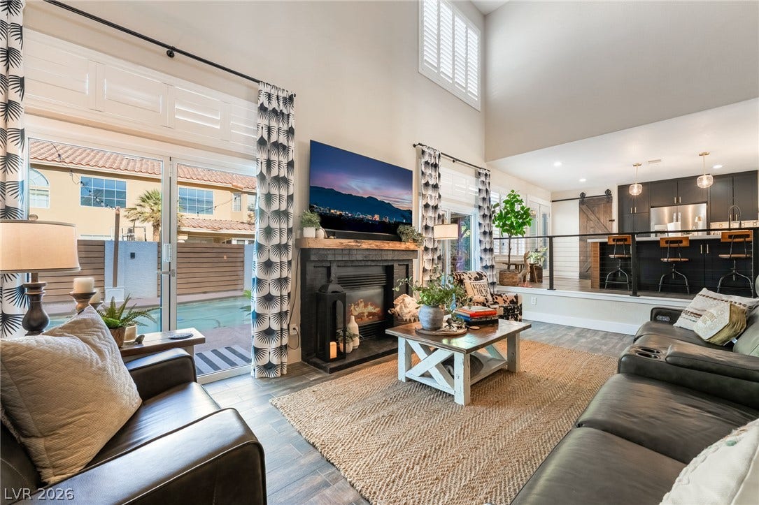 Towering ceilings and a modern fireplace define this open living area facing the pool.