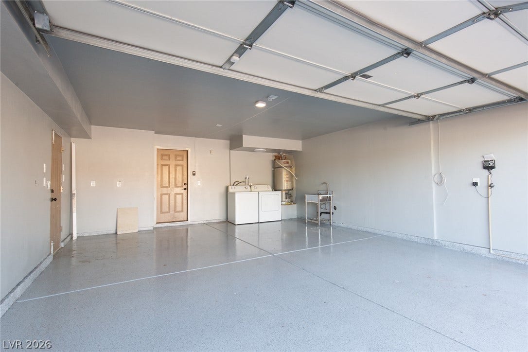 737 Brick Drive, Henderson, NV 89002 An expansive garage space features glossy finished concrete flooring and a designated laundry area.