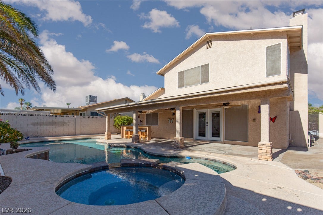 737 Brick Drive, Henderson, NV 89002 An inviting backyard oasis features a curved pool, integrated spa, and spacious covered patio.