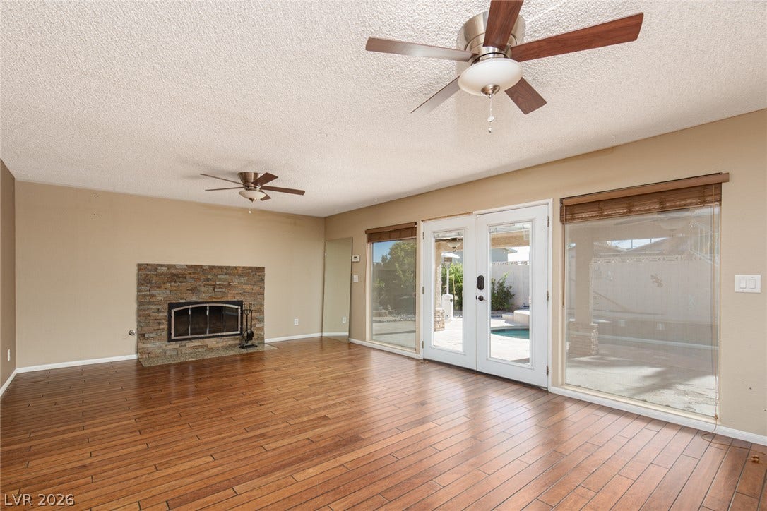 737 Brick Drive, Henderson, NV 89002 Rich wood floors and a stone-faced fireplace anchor this welcoming room with patio access.