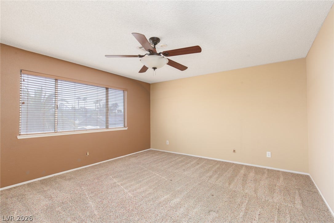 737 Brick Drive, Henderson, NV 89002 Soft carpeted flooring and a wide window with integrated blinds highlight this versatile room.