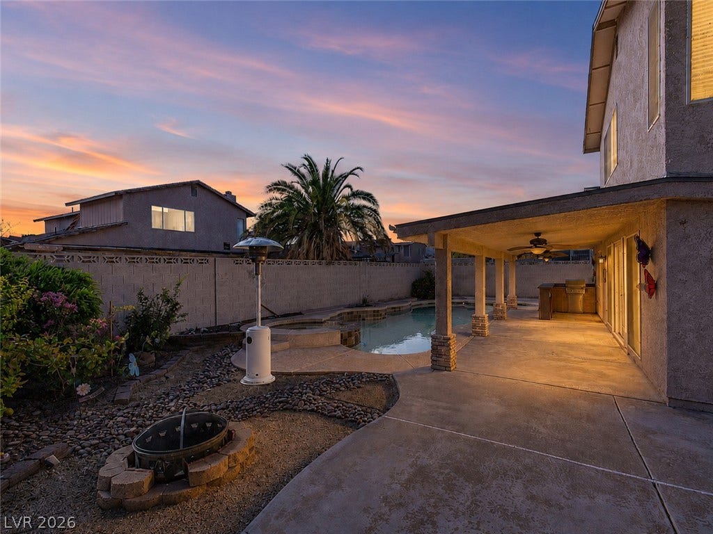 737 Brick Drive, Henderson, NV 89002 An inviting covered patio borders a private pool alongside structured stone landscaping details.