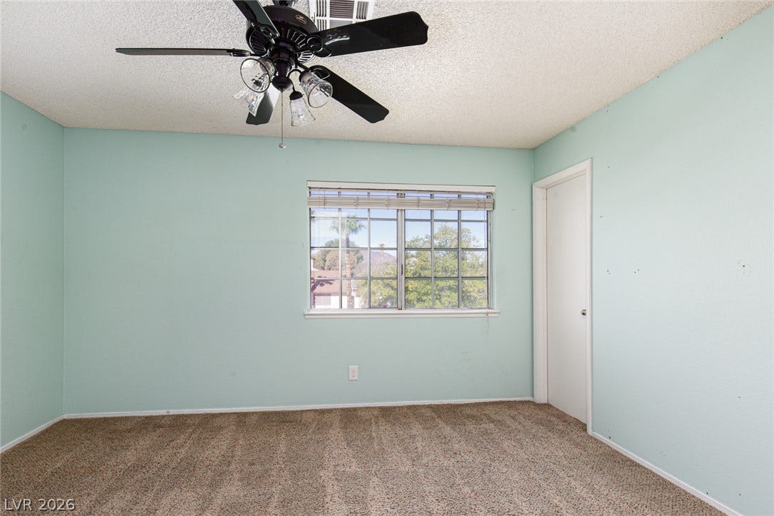 737 Brick Drive, Henderson, NV 89002 Plush carpeting anchors this bedroom containing a central window overlooking the neighborhood.