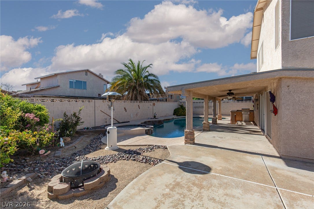 737 Brick Drive, Henderson, NV 89002 An inviting backyard features a covered patio alongside an in-ground pool and integrated spa.
