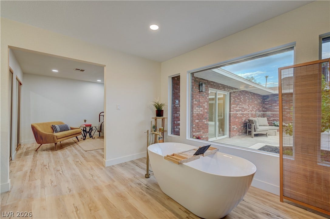 2101 Santiago Street, Las Vegas, NV 89104 Large picture windows overlook the courtyard from this bathroom featuring a freestanding soaking tub.