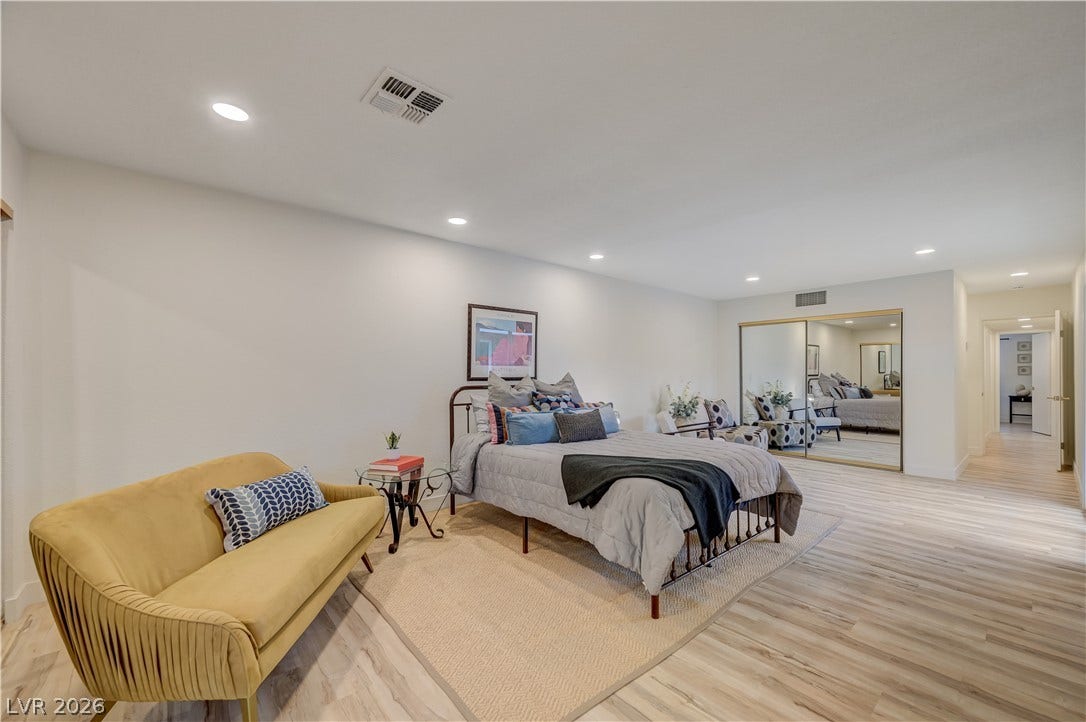 2101 Santiago Street, Las Vegas, NV 89104 Recessed lighting glows over wood-style floors in this airy, open bedroom suite.