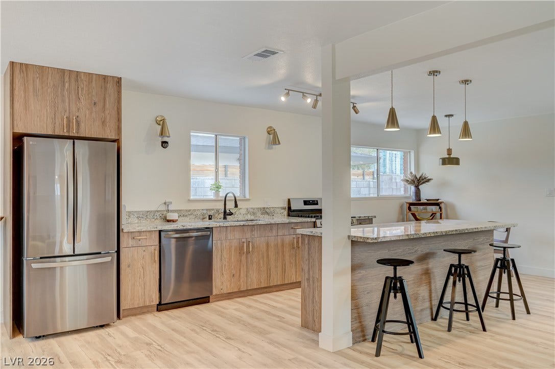 2101 Santiago Street, Las Vegas, NV 89104 Warm wood cabinetry and granite countertops anchor this open, sunlit kitchen.
