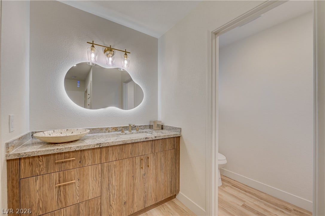 2101 Santiago Street, Las Vegas, NV 89104 Natural wood cabinetry and granite countertops create a serene, modern bathroom setting.