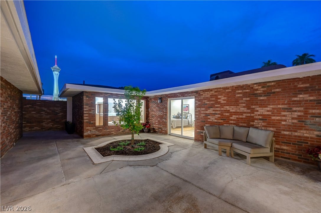 2101 Santiago Street, Las Vegas, NV 89104 Brick walls frame a private concrete courtyard offering views of the city skyline.