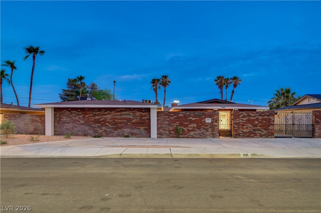 2101 Santiago Street, Las Vegas, NV 89104 Midcentury brick facade and concrete driveway under a twilight desert sky.