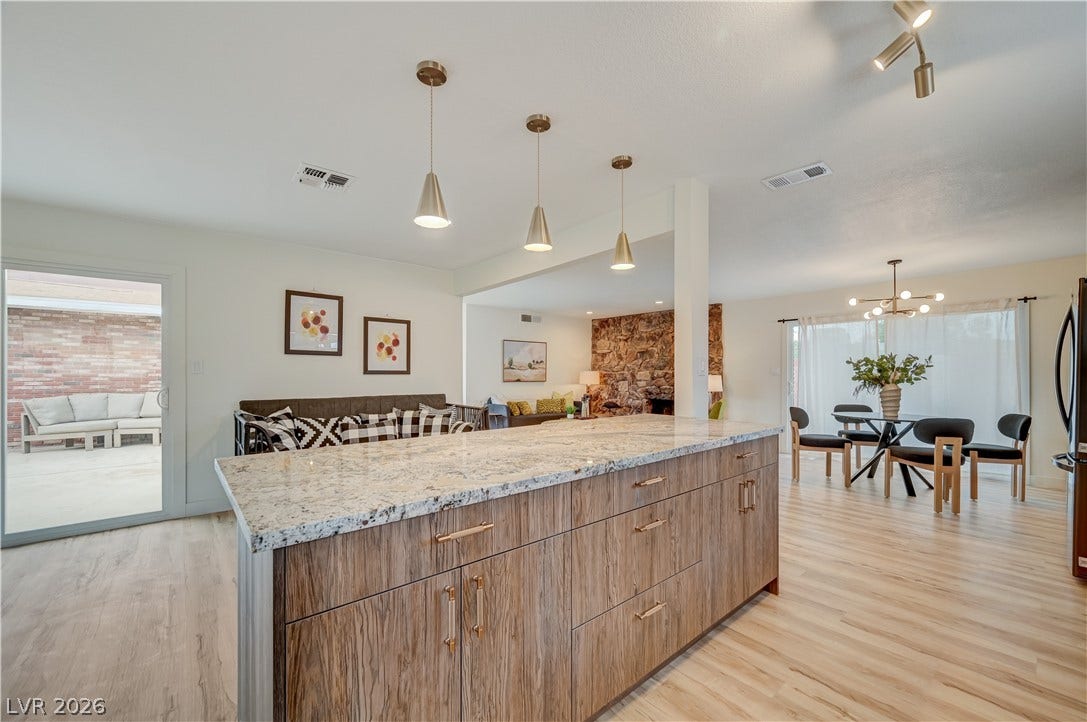 2101 Santiago Street, Las Vegas, NV 89104 Light-filled open interiors connect a stone-finished fireplace, spacious dining area, and central island.