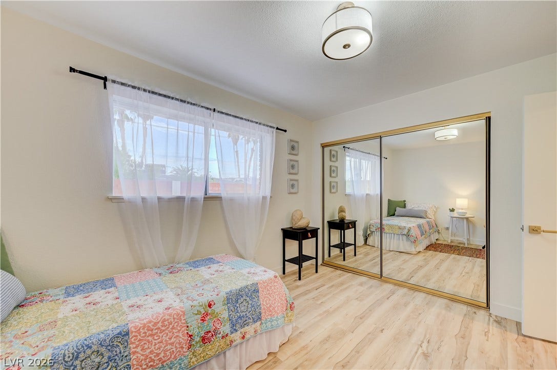 2101 Santiago Street, Las Vegas, NV 89104 Smooth wood-look flooring and mirrored closet doors enhance this light-filled bedroom space.
