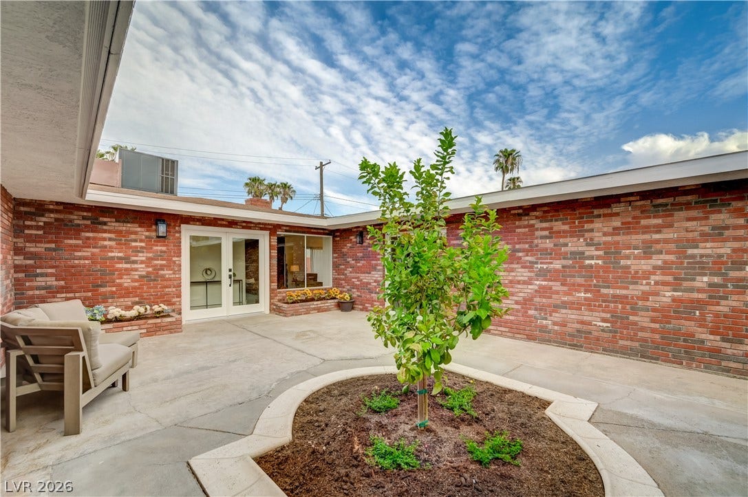 2101 Santiago Street, Las Vegas, NV 89104 A classic brick exterior surrounds this spacious concrete courtyard centered around a circular garden planter.