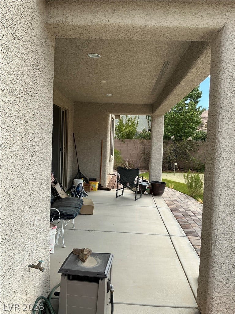 A sheltered concrete patio links the home's interior with the landscaped backyard.