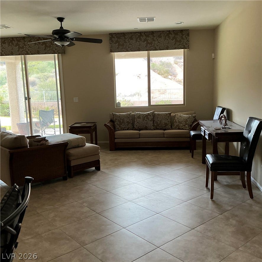Tiled flooring and large windows create a bright foundation for this versatile living space.