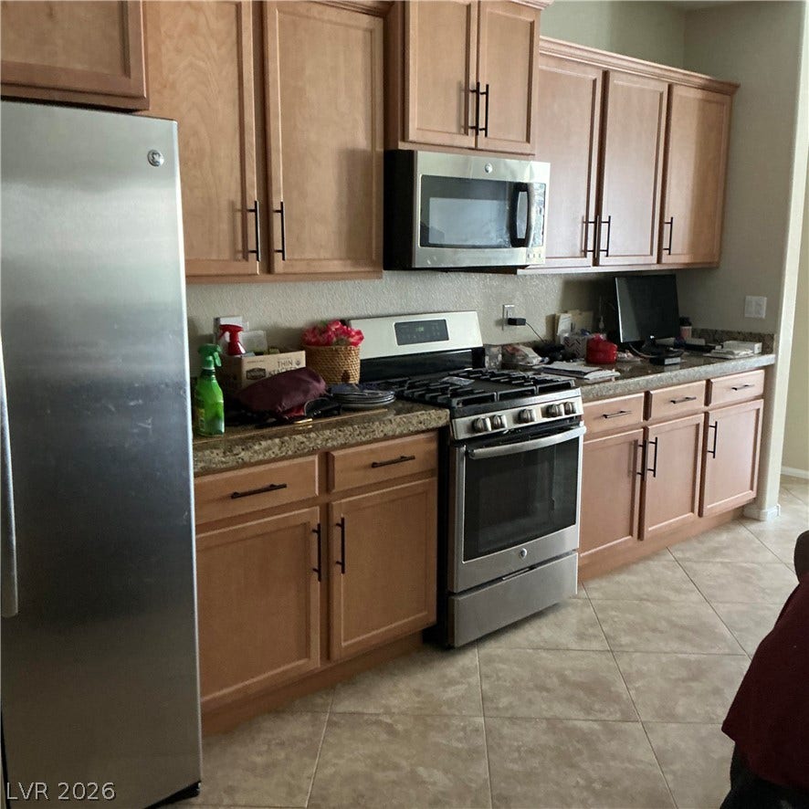 Ample wooden cabinetry and stone counters define this fully equipped kitchen space.