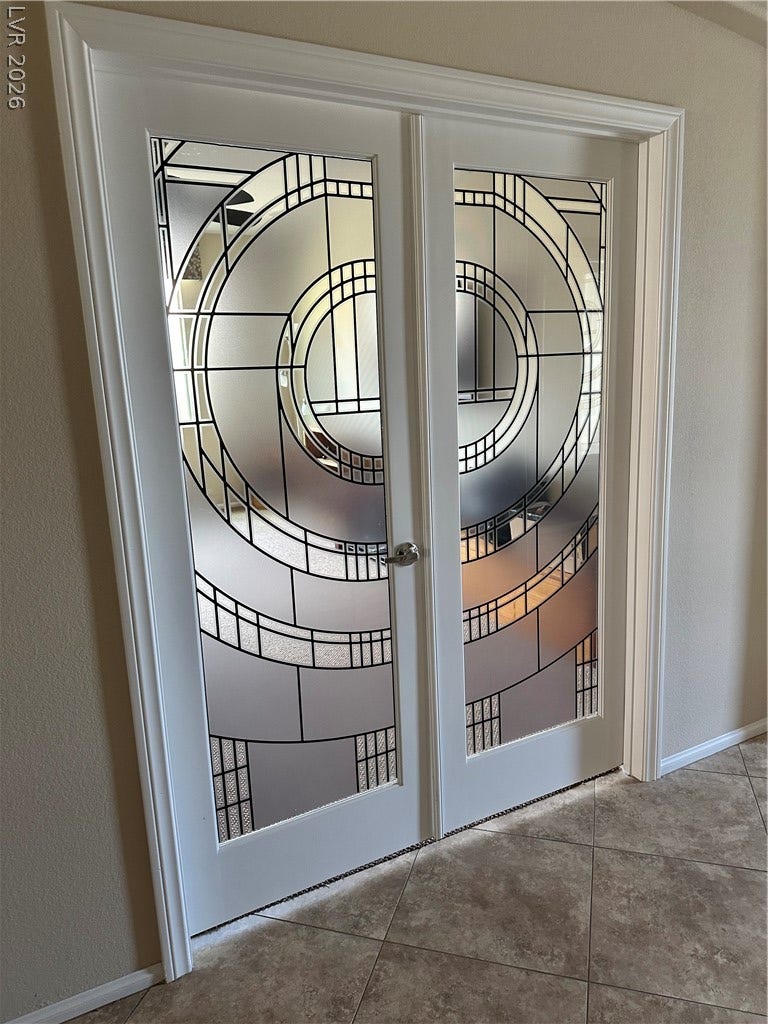Double doors with leaded glass panels open into a tile-floored entryway.