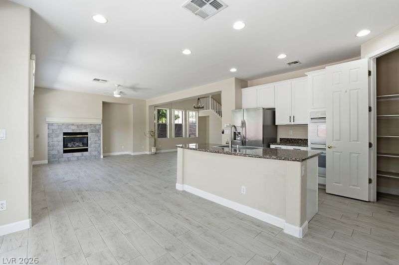 10464 Calico Pines Avenue, Las Vegas, NV 89135 An open layout connects the kitchen to a bright living area anchored by a fireplace.
