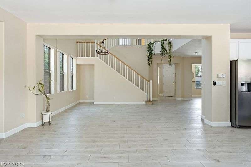 10464 Calico Pines Avenue, Las Vegas, NV 89135 An open floor plan reveals light wood-look tile flooring and a central staircase.