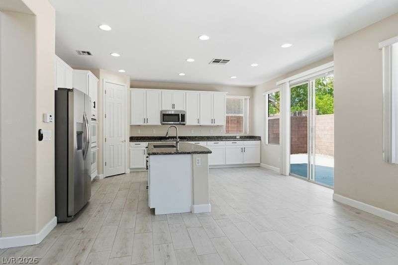 10464 Calico Pines Avenue, Las Vegas, NV 89135 Granite counters and light wood-look tile floors define this airy, open-concept culinary space.
