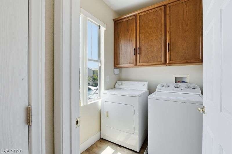 10464 Calico Pines Avenue, Las Vegas, NV 89135 An organized laundry area features overhead wood cabinetry and a tall window.