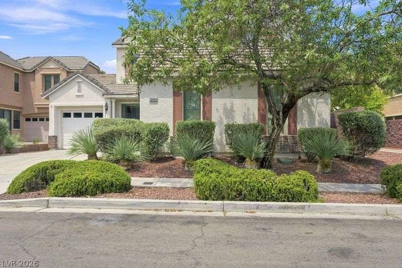 10464 Calico Pines Avenue, Las Vegas, NV 89135 Mature trees and low-maintenance plantings frame the entry of this classic stucco home.