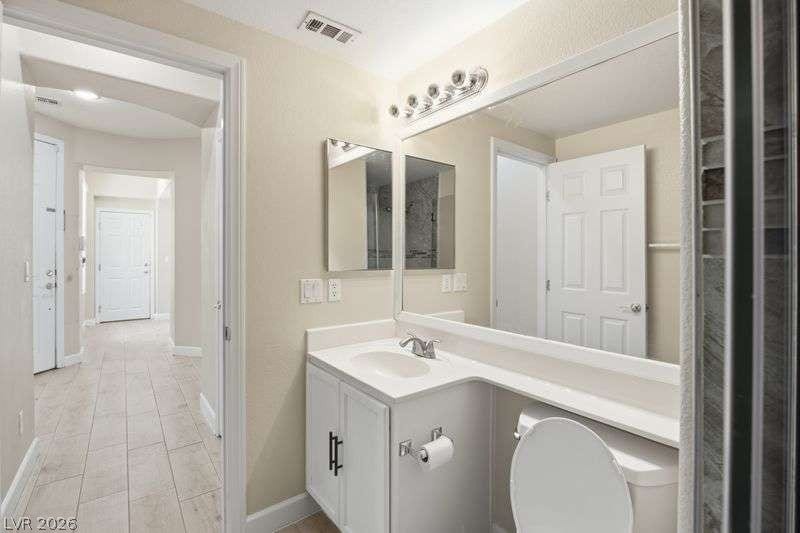 10464 Calico Pines Avenue, Las Vegas, NV 89135 Gleaming tile floors stretch from the hallway into this well-appointed guest bathroom.