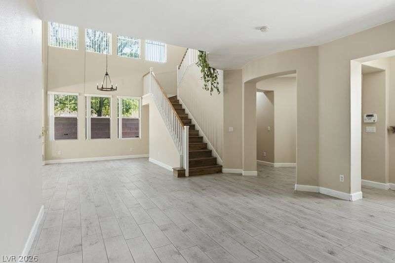 10464 Calico Pines Avenue, Las Vegas, NV 89135 An open floorplan connects the main living areas with wood-look flooring and soaring double-height ceilings.
