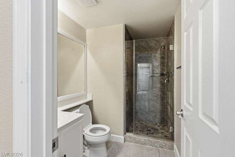 10464 Calico Pines Avenue, Las Vegas, NV 89135 A glass-enclosed walk-in shower pairs with durable tile flooring in this functional bathroom.