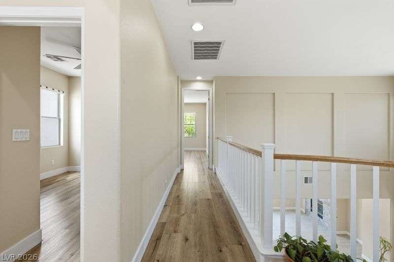 10464 Calico Pines Avenue, Las Vegas, NV 89135 A light-filled upper hallway showcases handsome wood-look floors alongside a classic white railing.