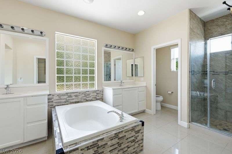 10464 Calico Pines Avenue, Las Vegas, NV 89135 Tiled accents and polished finishes frame a spacious soaking tub and dual vanities.