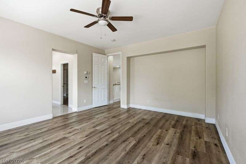 10464 Calico Pines Avenue, Las Vegas, NV 89135 Rich wood-look flooring and clean white baseboards anchor this versatile upstairs bonus room.