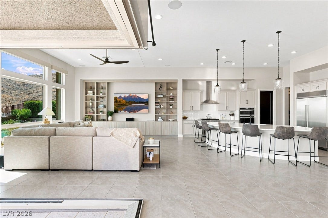 An open floor plan seamlessly connects the kitchen and main living areas under towering ceilings.