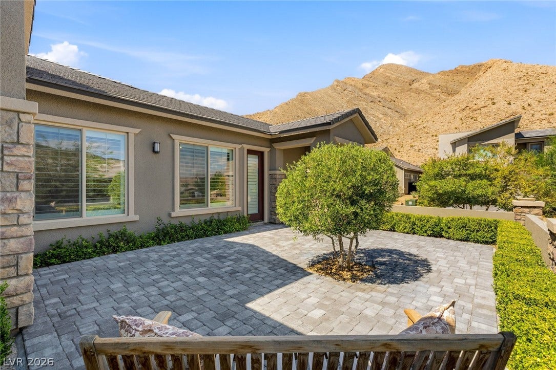Stone pavers line this enclosed front courtyard framed by dramatic desert mountain views.