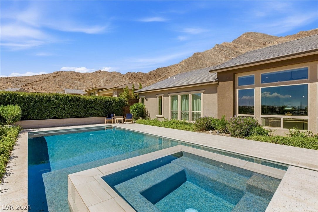 Dramatic mountain peaks frame a sparkling pool and spa.