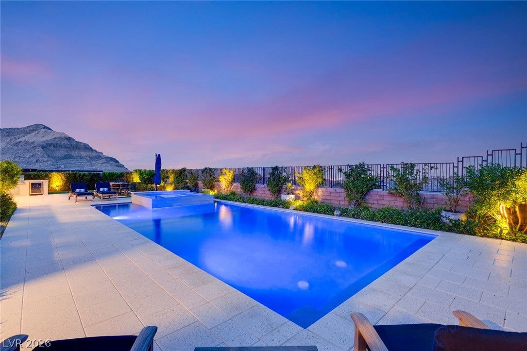 An inviting swimming pool and spa sit against a backdrop of majestic mountain views.